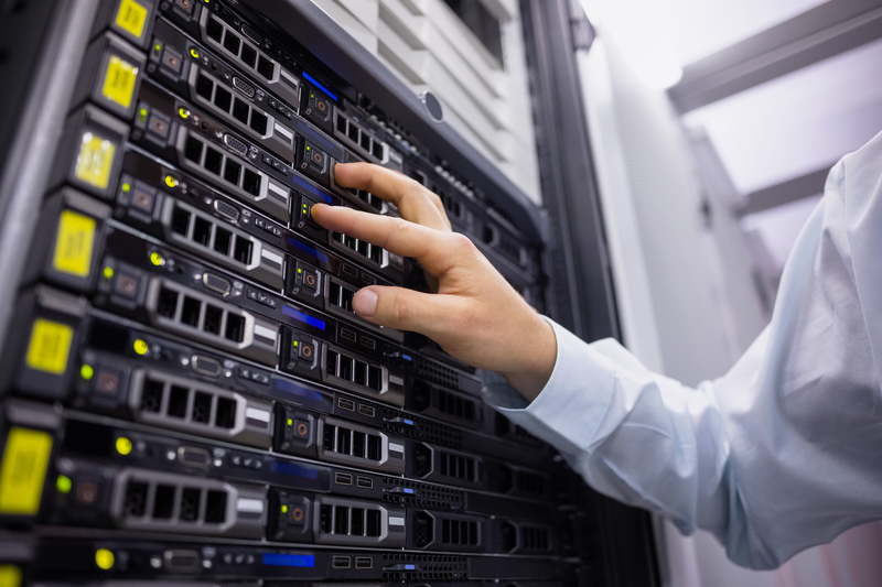 Technician working on server tower in large data center Technicican working on server tower in large data center